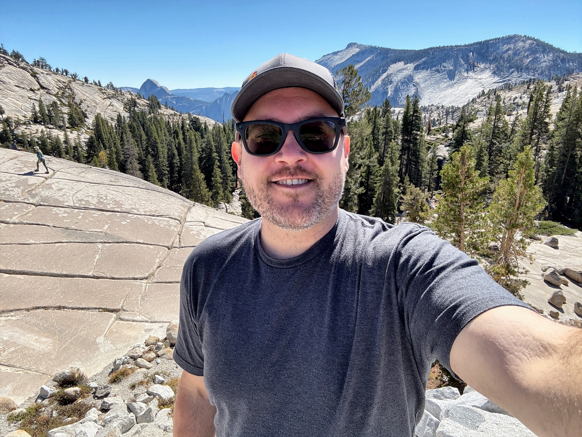 Jon selfie with Half Dome and Yosemite Valley visible behind him on a sunny day