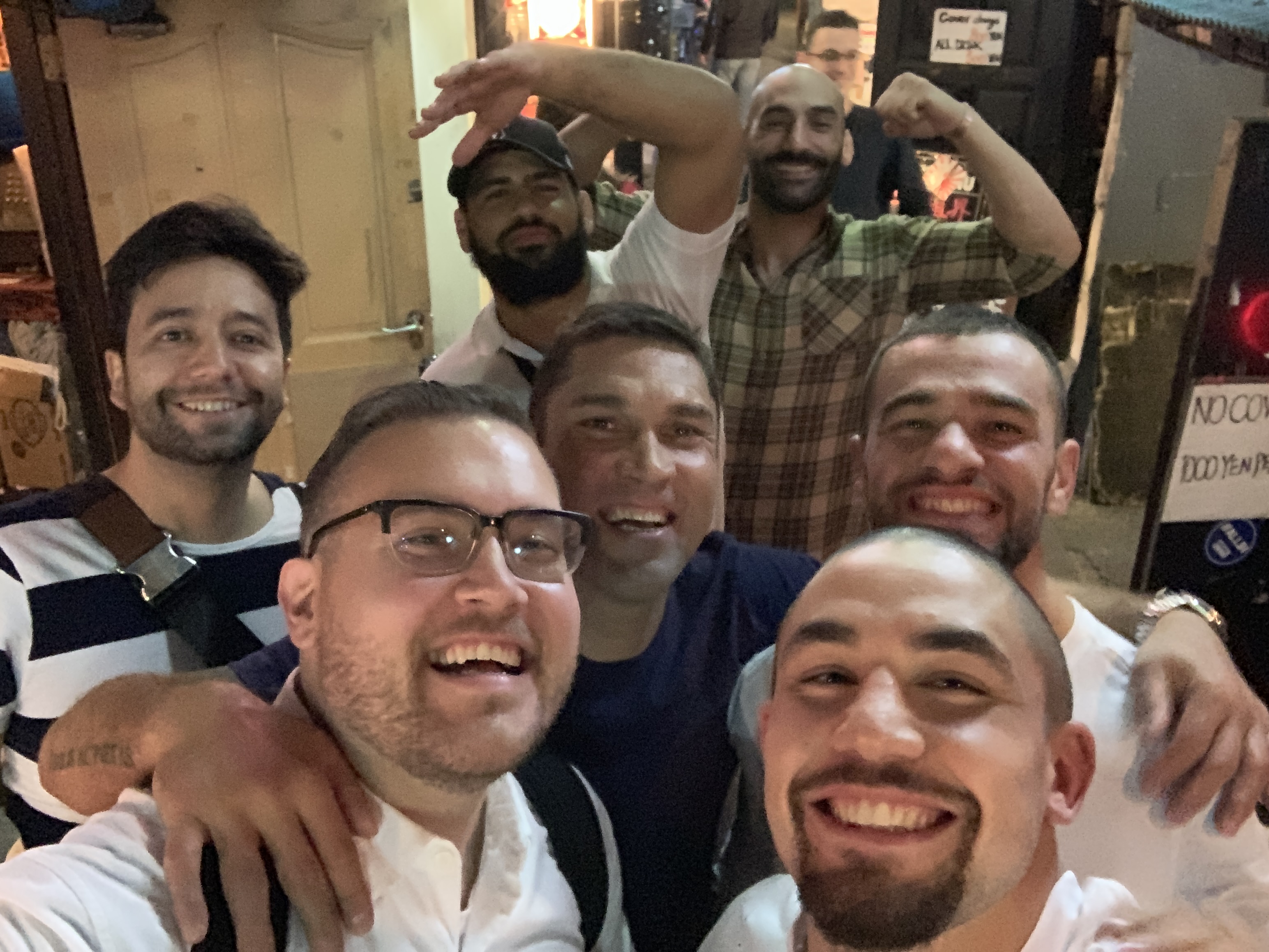 Jon with a big group of friends laughing and taking a selfie at night in Japan